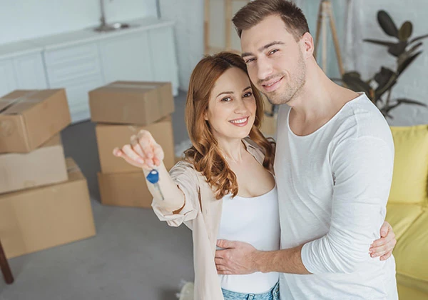 Couple souriant tenant les clés de son nouveau logement pour l'aide relative au logement et dossier social par SOCIALP