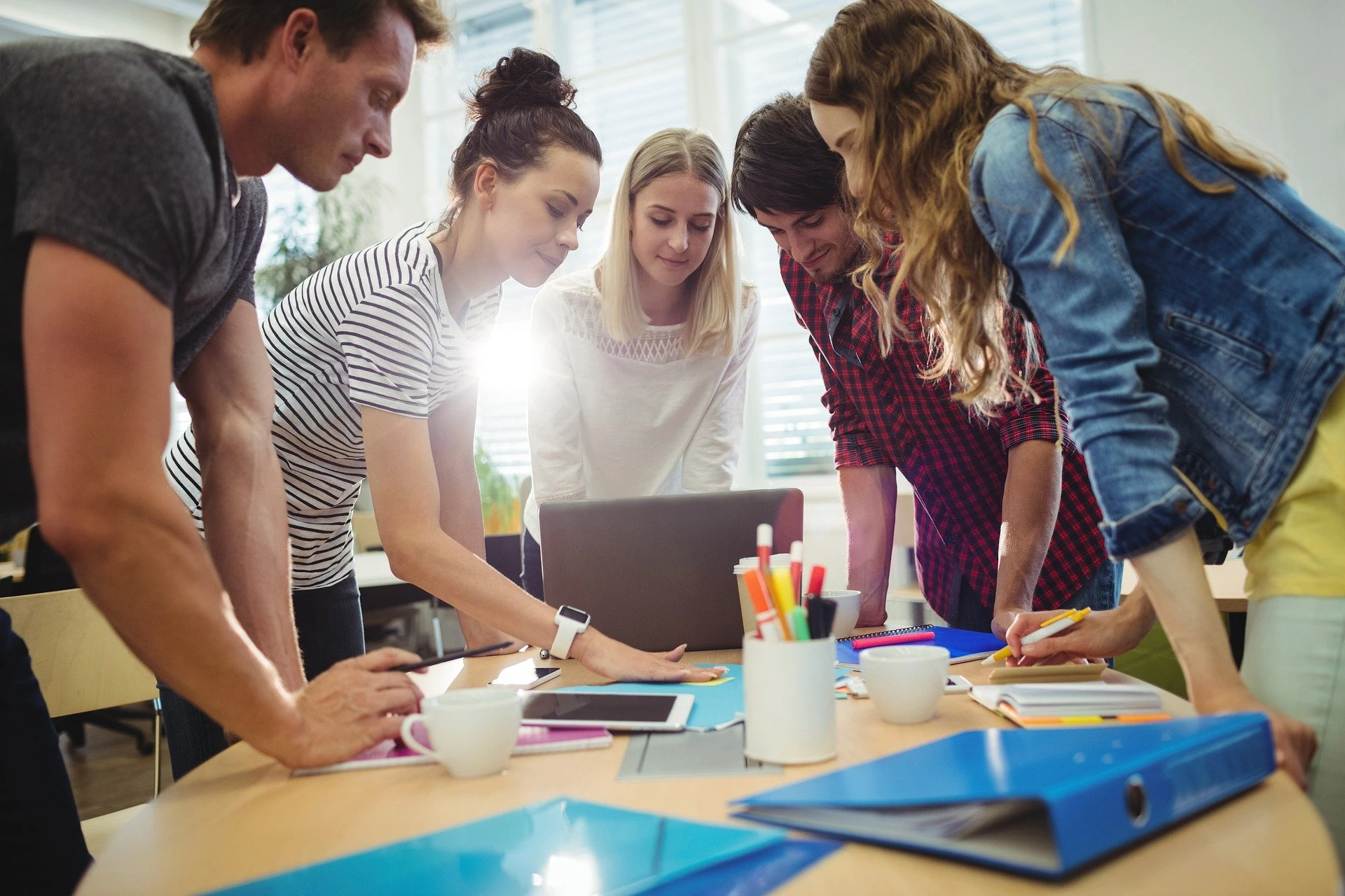 Groupe d'étudiants et d'intervenants penchés autour d'une table de travail lors d'un atelier en organisme de formation avec SOCIALP