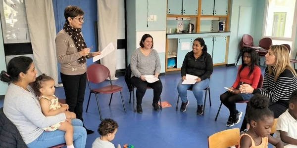 Atelier collectif et de parentalité réunissant des mères et leurs enfants en cercle pour le programme d'insertion sociale SOCIALP